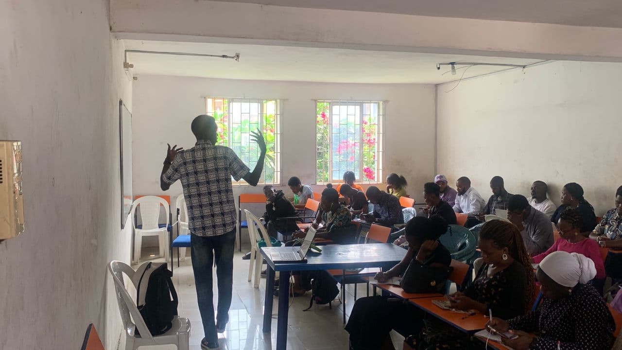 Muyiwa Adekojede teaching a full class in a bright classroom
